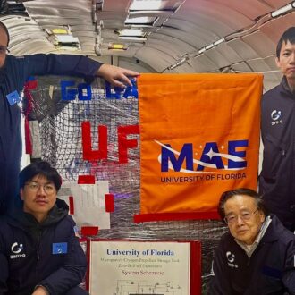 A group of six individuals in matching uniforms poses inside an aircraft, with banners from the University of Florida and MAE pinned on equipment.