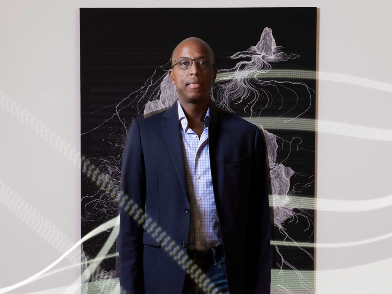 A photo of David Prevatt standing in front of an abstract image.