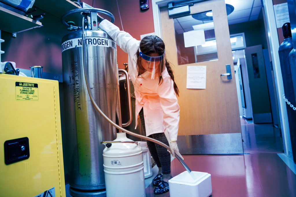 UF chemistry lab technician wearing PPE while handling chemicals.