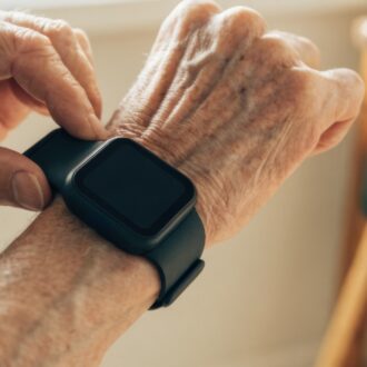 Elderly hands wearing a smartwatch.